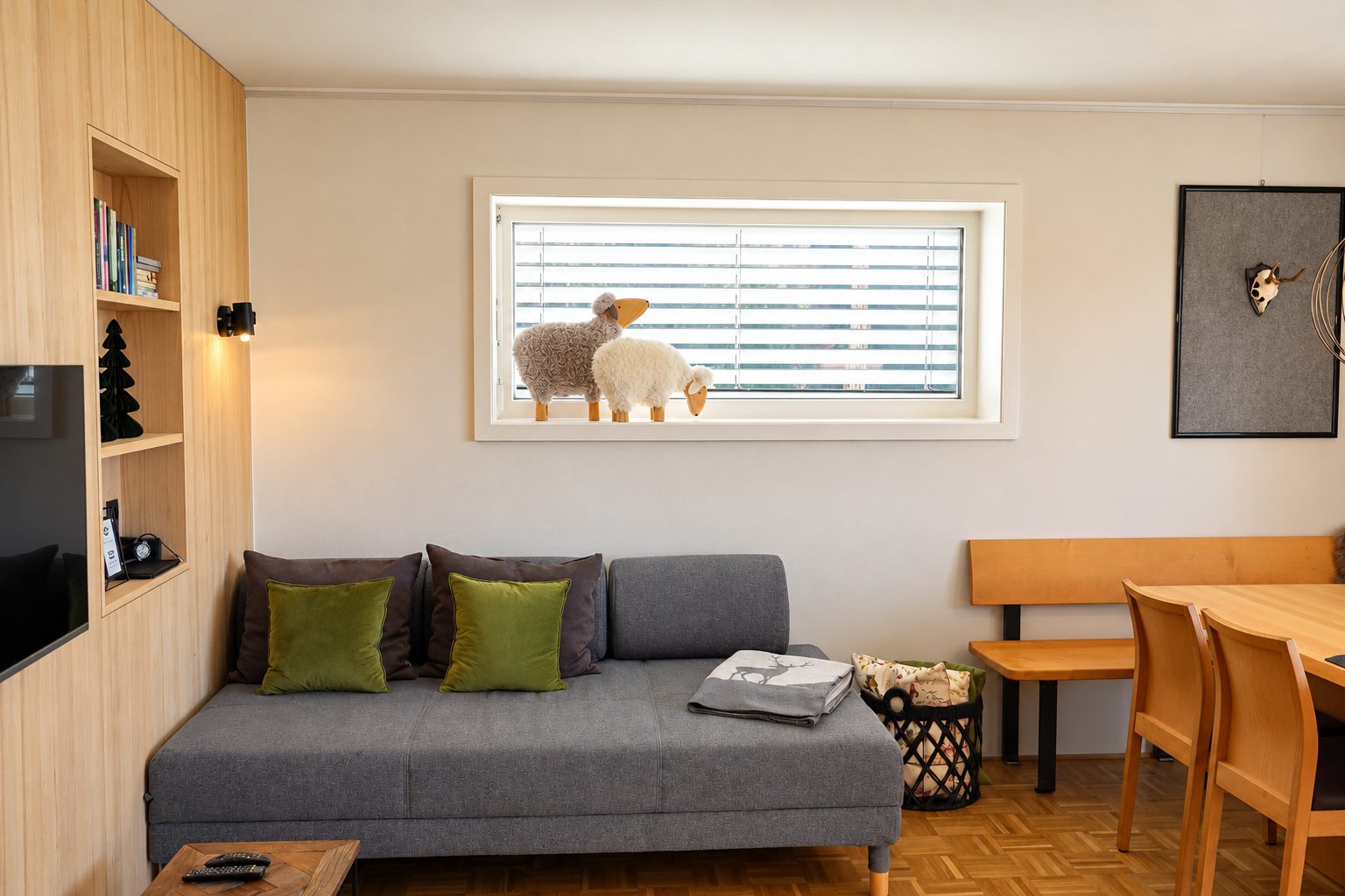 Wohnbereich der Ferienwohnung mit Sofa und Schafen am Fenster, Ferien am Bach Riefensberg, Bregenzerwald